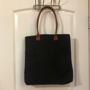Dark grey purse with brown straps.